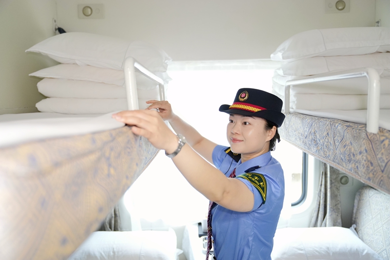 中越国际旅客列车列车长兰秋霜整理卧铺卧具。曹烁摄