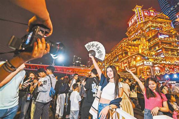 渝中区洪崖洞景区，外国游客在拍照打卡。（资料图片） 首席记者 龙帆 摄/视觉重庆