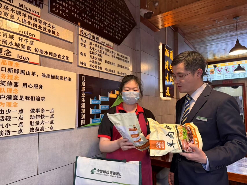 郵儲銀行工作人員在“羊老頭”羊肉粉館了解經營情況。郵儲銀行六盤水市分行供圖.jpg