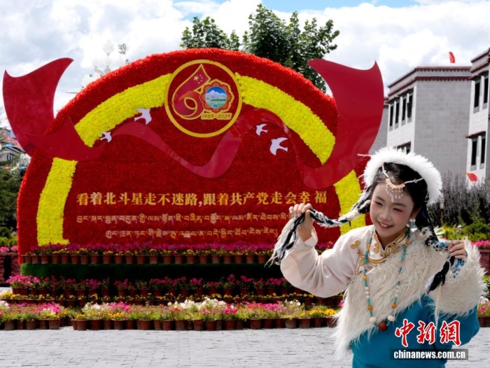 8月19日，隨著西藏自治區(qū)成立60周年慶?；顒?dòng)臨近，拉薩氛圍濃。拉薩街頭，處處是張燈結(jié)彩的盛景，洋溢著一派祥和與歡騰的氛圍。圖為游客在拉薩大昭寺廣場(chǎng)上的大慶宣傳標(biāo)語前留念。<a target='_blank' href='/'>中新社</a>記者 李林 攝