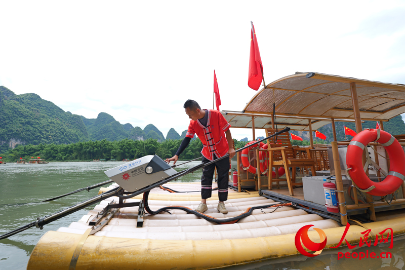 筏工鄭海波在操作竹筏。人民網(wǎng) 梁章暉攝